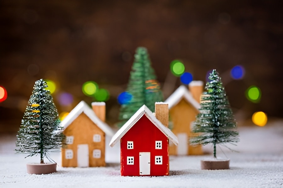 Miniature Christmas houses and frosted pine trees, representing NOVADECI Christmas loan financing