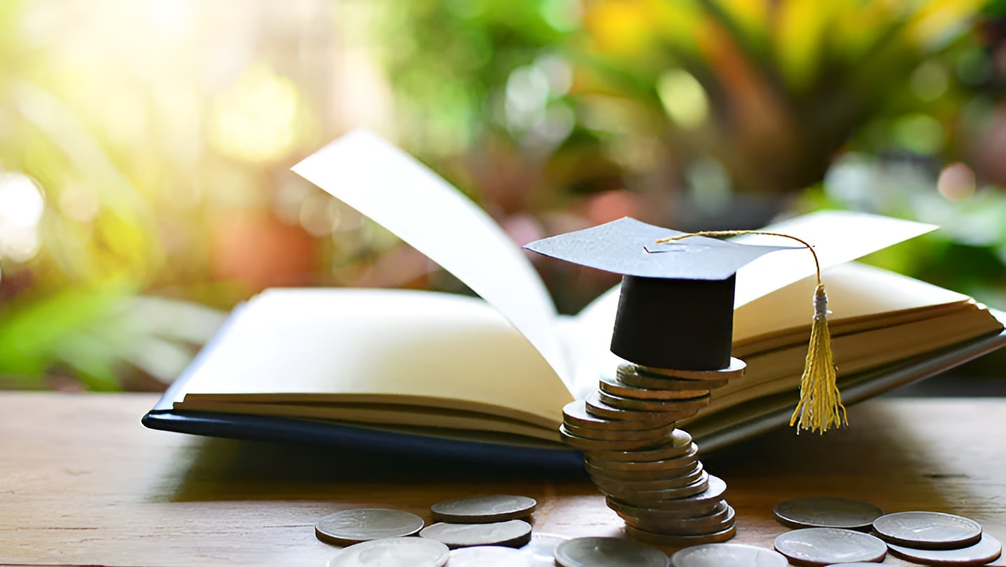 Graduation cap, open book, and coins, representing NOVADECI educational loan financing