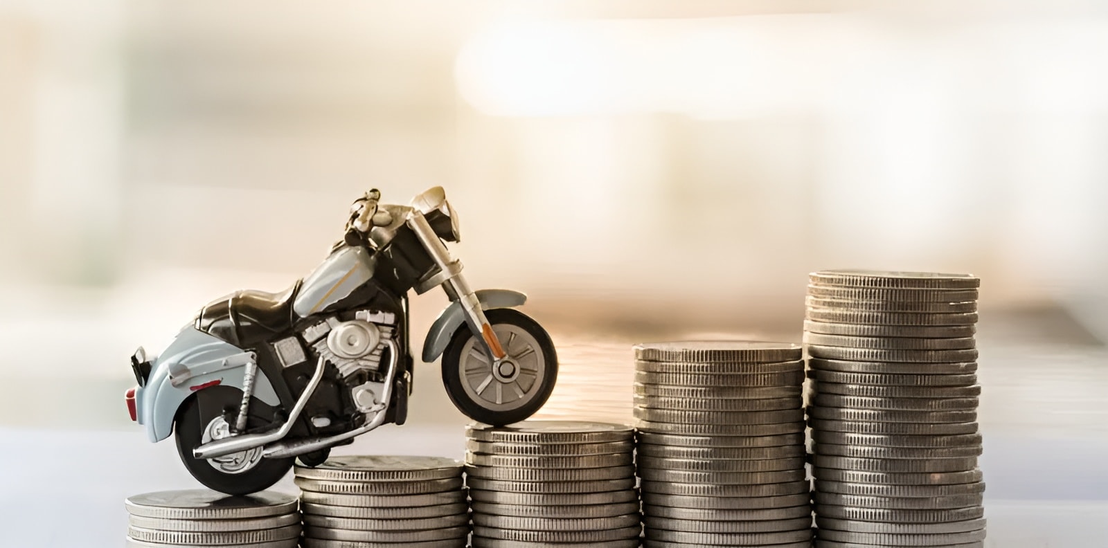 Toy motorcycle beside stacks of coins, representing NOVADECI motorcycle loan financing