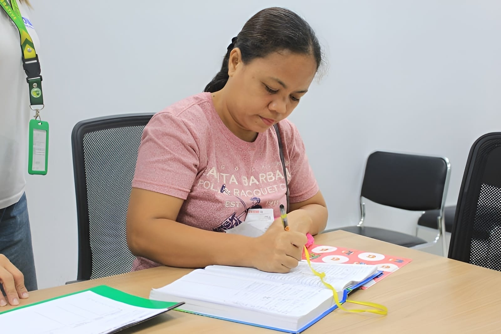 NOVADECI staff assisting a member with paperwork at the office