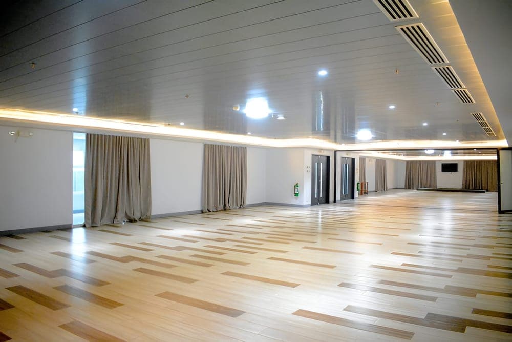 Spacious function room with wooden flooring and white walls